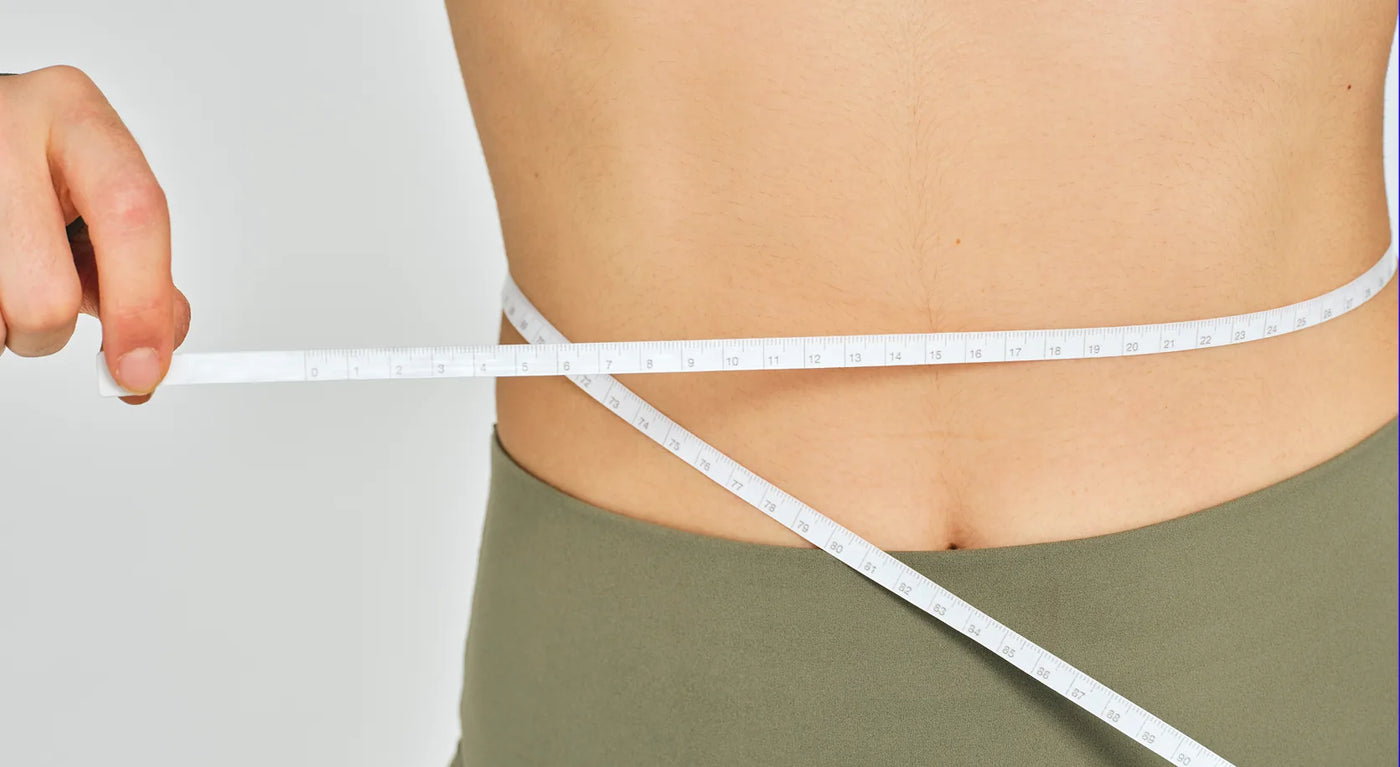 Woman measuring her waist
