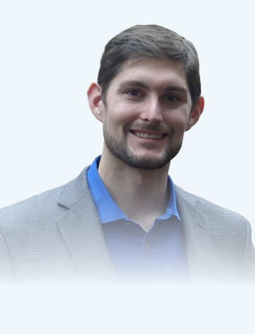 Man wearing a light gray blazer over a blue shirt against a white background