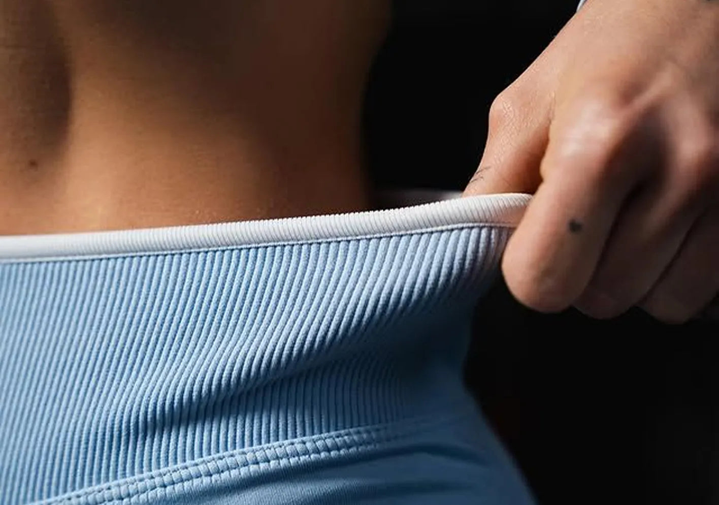 Person wearing a light blue off-shoulder top with a close-up of the fabric texture.