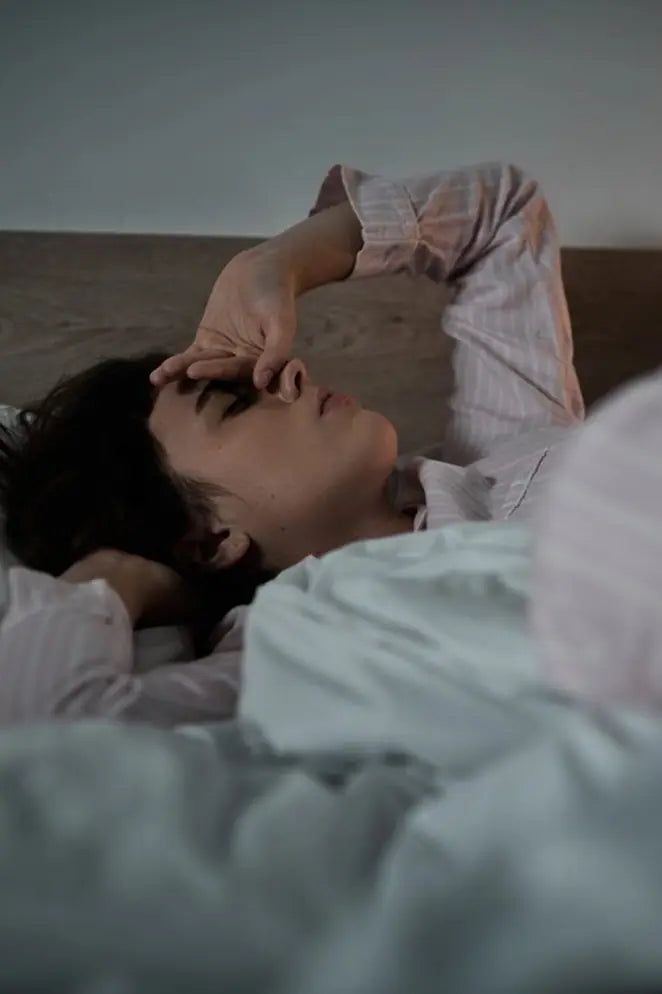 Person lying in bed with a light blue blanket